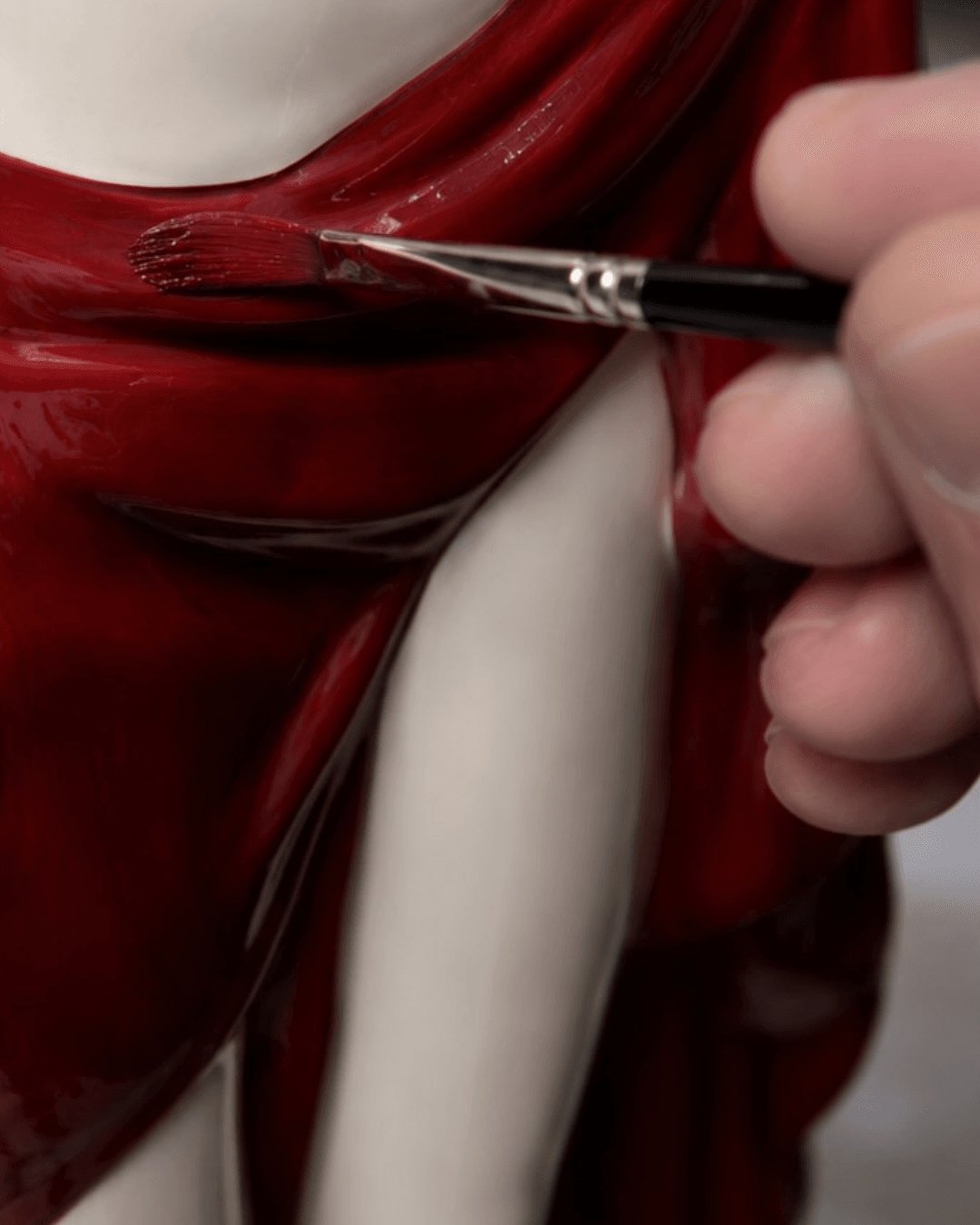 Hand painting the drape of the Dyane porcelain sculpture